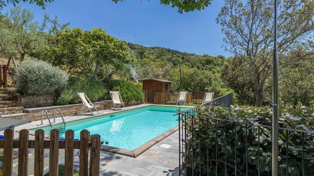 - une piscine avec deux chaises dans la cour dans l'établissement I Mandorli 8, Emma Villas, à Cortone