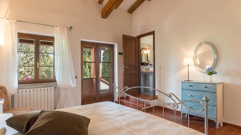 - une chambre avec un lit, un miroir et une commode bleue dans l'établissement Podere Calcheto 14, Emma Villas, à Montecatini Val di Cecina 42 autres photos