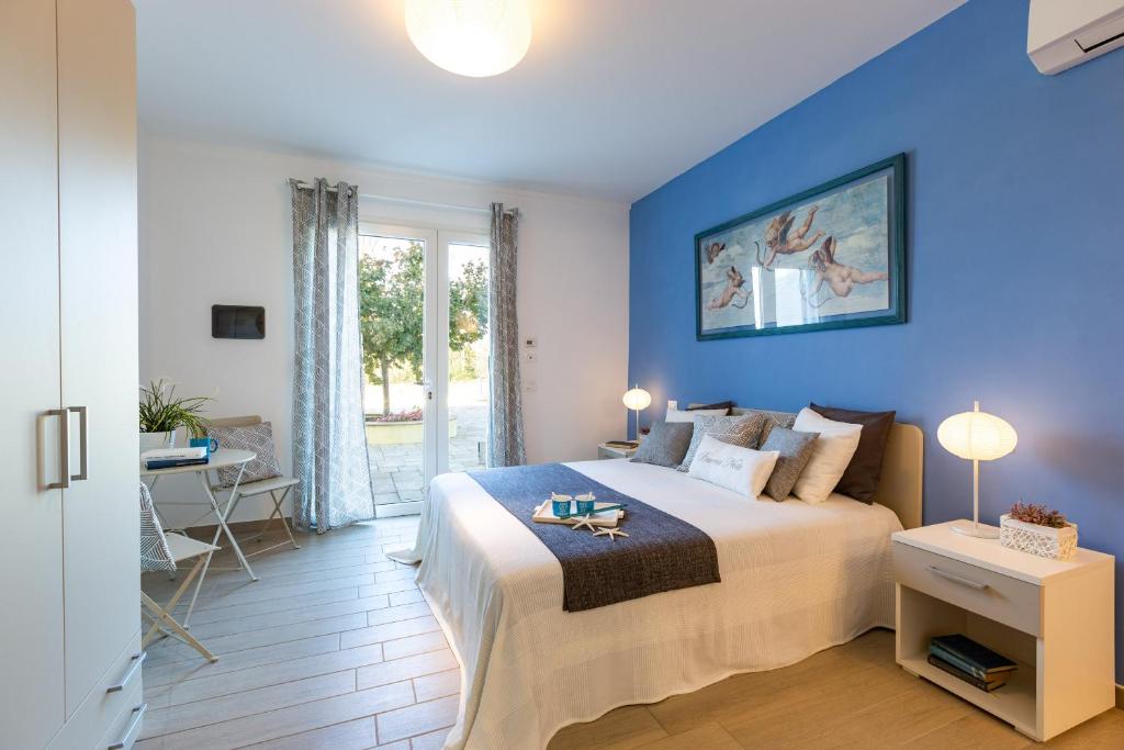 - une chambre bleue avec un grand lit et une table dans l'établissement IL NOCCIOLO 12, Emma Villas, à Cecina 44 autres photos