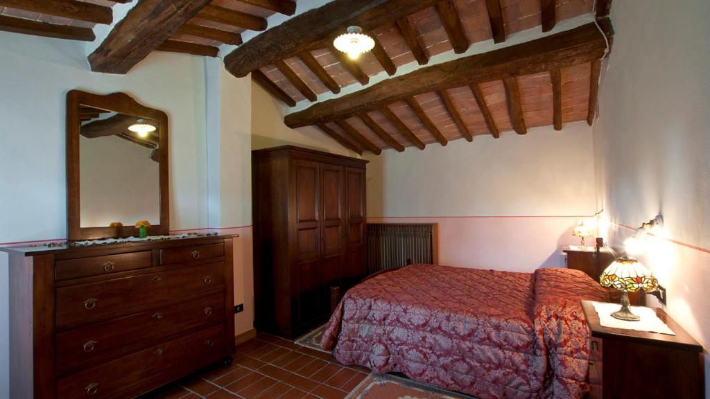 une chambre avec un lit, une commode et un miroir dans l'établissement FRANTUSA 6&2, Emma Villas, à Volterra 44 autres photos