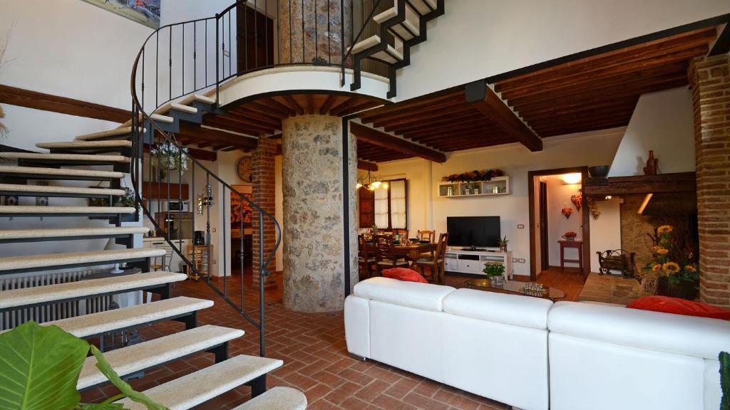 - un salon avec un canapé blanc et un escalier dans l'établissement LA CAPANNA DI FRANCA 6&2, Emma Villas, à Sovicille