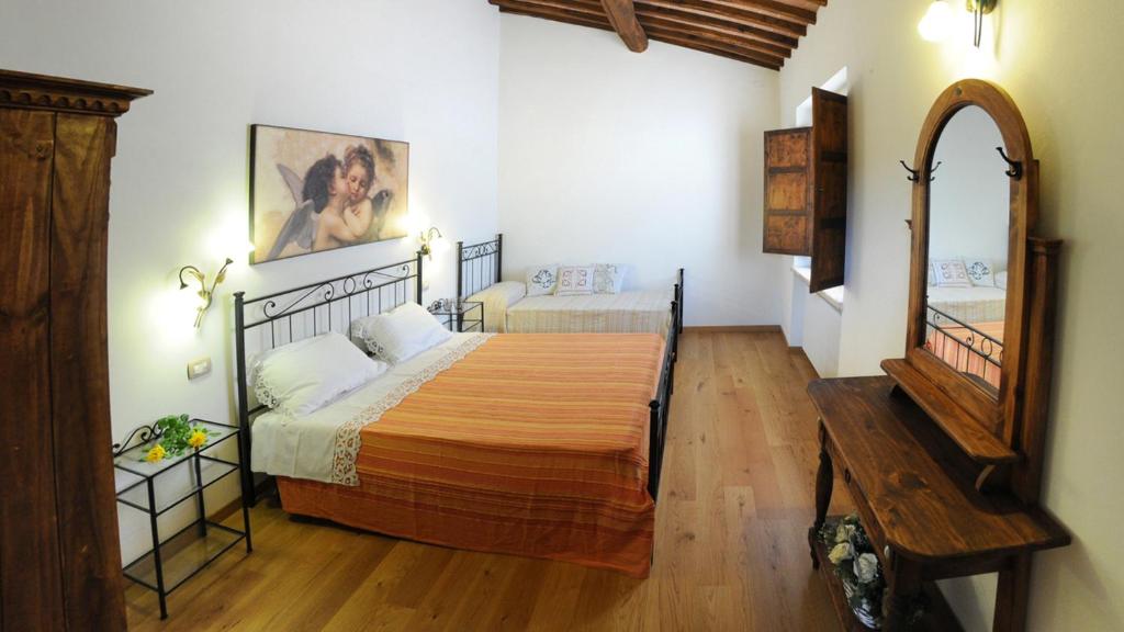 une chambre avec un grand lit et un miroir dans l'établissement LA CAPANNA DI FRANCA 6&2, Emma Villas, à Sovicille 31 autres photos