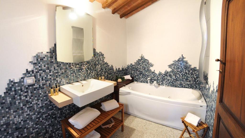 une salle de bain avec une baignoire et un lavabo et une baignoire dans l'établissement LA CAPANNA DI FRANCA 6&2, Emma Villas, à Sovicille