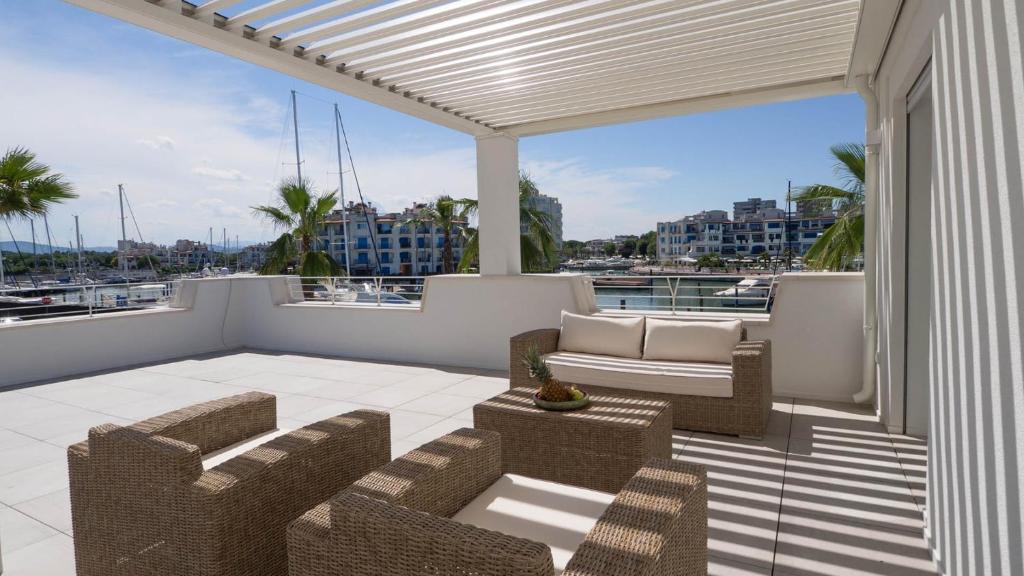 d'une terrasse avec des chaises et un canapé sur un balcon. dans l'établissement PORTOVERDE BEACH VILLA 12, Emma Villas, à Misano Adriatico