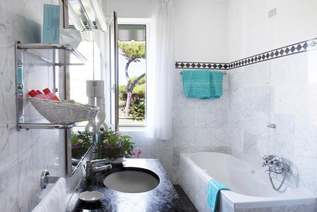 La salle de bains est pourvue d'un lavabo, d'une baignoire et d'une fenêtre. dans l'établissement President Hotel, à Forte dei Marmi 57 autres photos