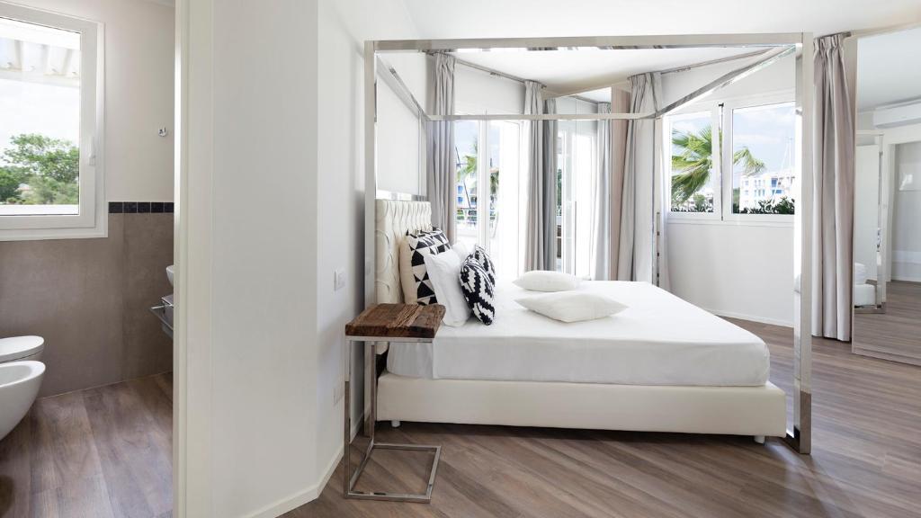 - une chambre blanche avec un lit à baldaquin et une salle de bains dans l'établissement PORTOVERDE BEACH VILLA 12, Emma Villas, à Misano Adriatico