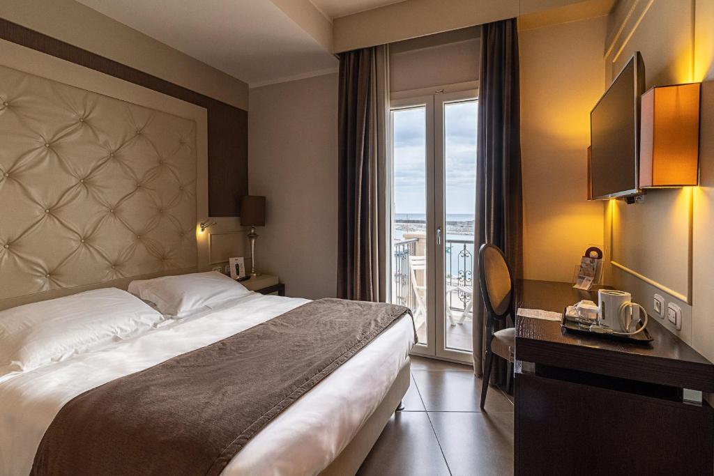 une chambre d'hôtel avec un grand lit et une fenêtre dans l'établissement Best Western Plus Hotel Perla Del Porto, à Catanzaro Lido