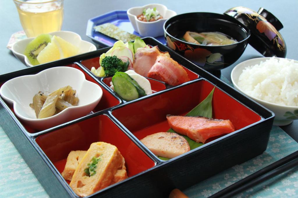 un plateau avec trois plateaux de nourriture sur une table dans l'établissement Lodge Clubman, à Hachimantai
