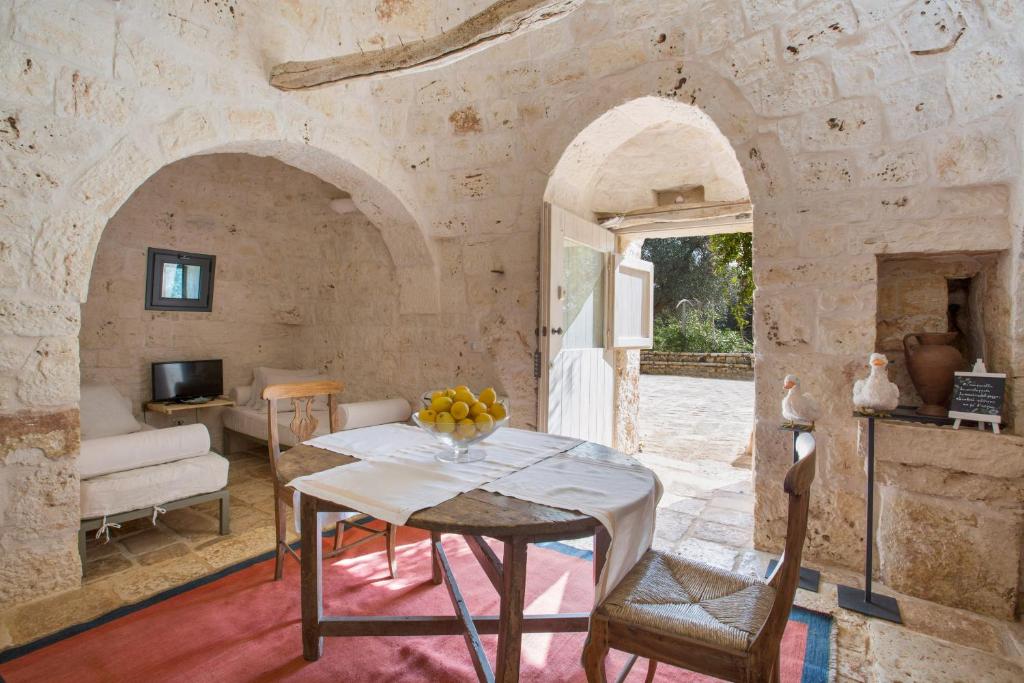 - un salon avec une table dans un mur en pierre dans l'établissement Trullo dell'Oleandro - Le Corti del Silenzio, à Ceglie Messapica