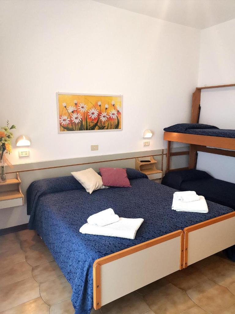 une chambre avec un lit avec deux serviettes dessus dans l'établissement Hotel Alcazar, à Rimini