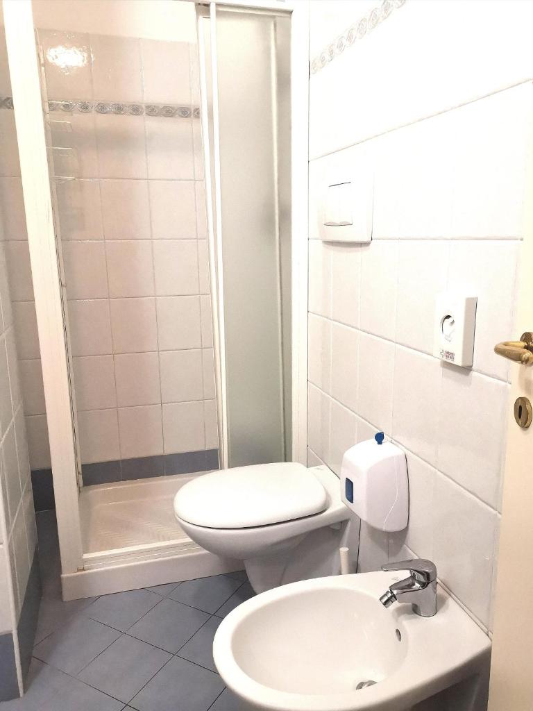 une petite salle de bain avec toilettes et douche dans l'établissement Hotel Alcazar, à Rimini
