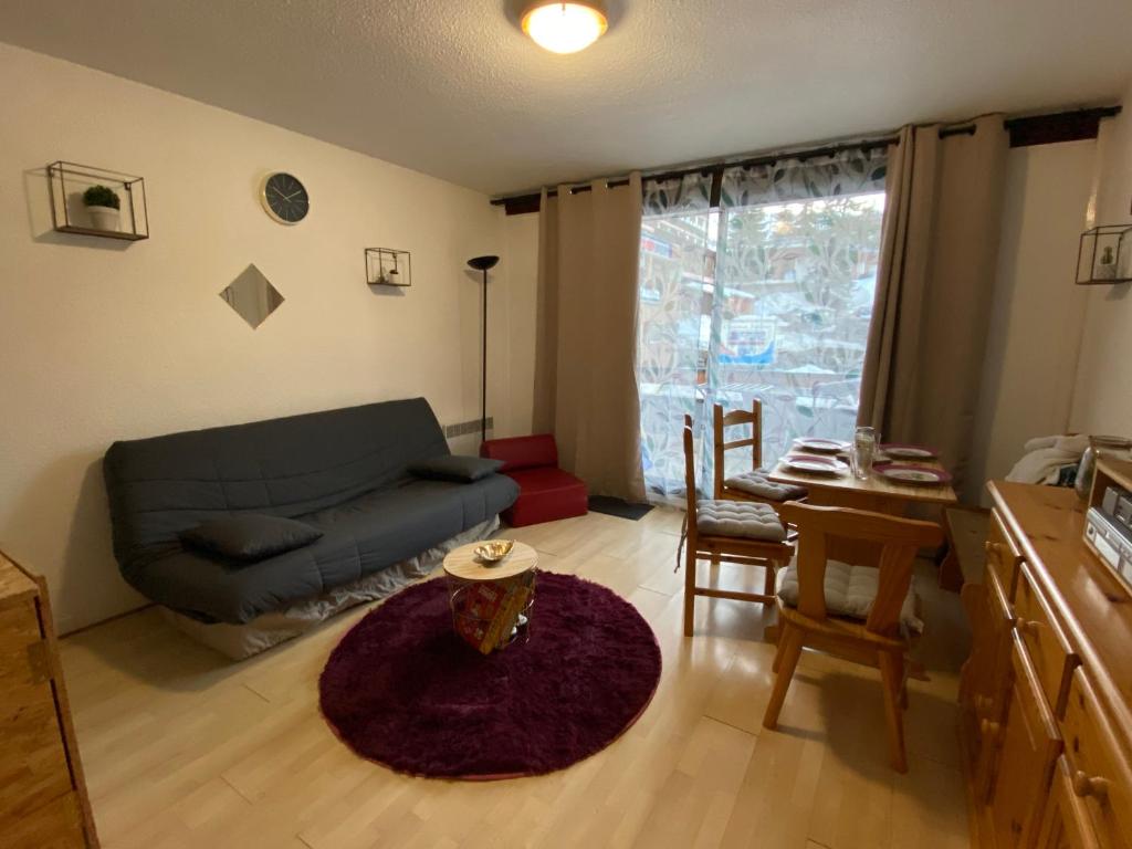 un salon avec un canapé et une table dans l'établissement Au pied des pistes (Le Corbier/73), à Villarembert