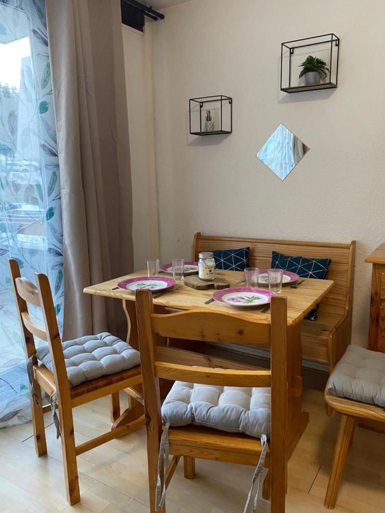 - une table à manger avec 2 chaises et une table en bois dans l'établissement Au pied des pistes (Le Corbier/73), à Villarembert 4 autres photos
