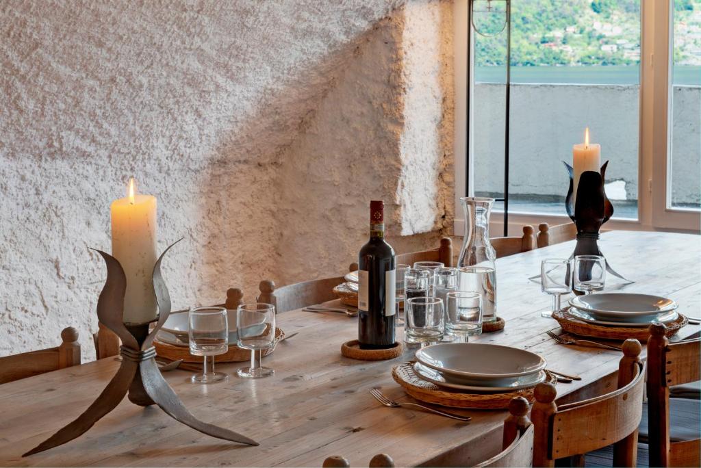- une table en bois avec une bougie et des bouteilles de vin dans l'établissement La Filanda - The House Of Travelers, à Brienno