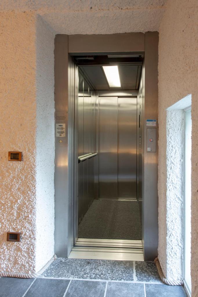 un ascenseur métallique sur le côté d'un bâtiment dans l'établissement La Filanda - The House Of Travelers, à Brienno