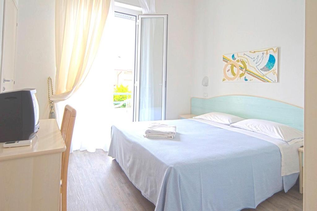 une chambre avec un lit, une télévision et une fenêtre dans l'établissement Hotel Vienna, à Bellaria-Igea Marina