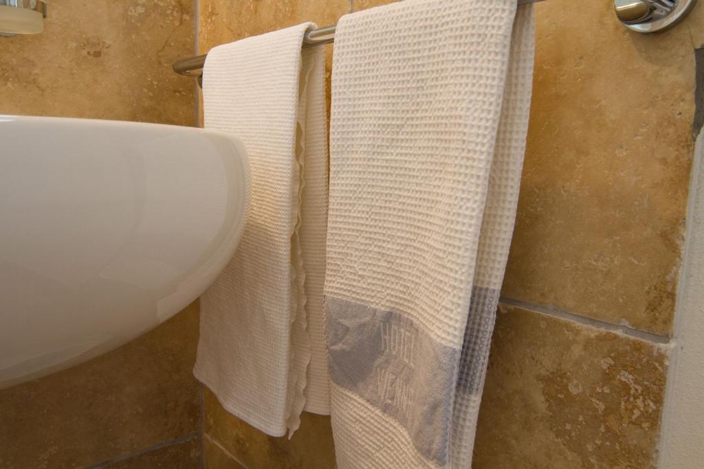 une salle de bain avec un lavabo blanc et deux serviettes dans l'établissement Hotel Vienna, à Bellaria-Igea Marina