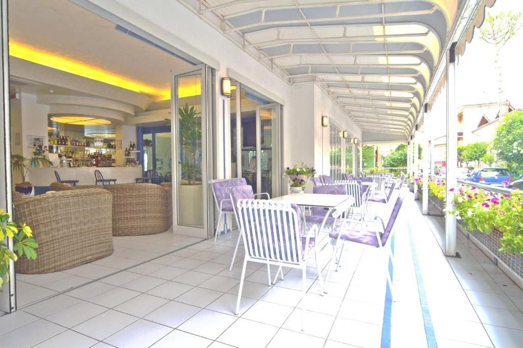 un patio avec une table et des chaises et un restaurant dans l'établissement Hotel Vienna, à Bellaria-Igea Marina
