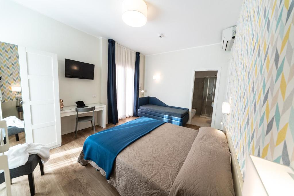 une chambre avec un lit et un bureau dans l'établissement Hotel Kiss, à Riccione