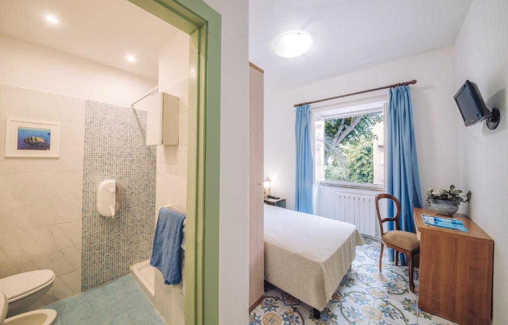 une chambre avec un lit et une salle de bain avec douche dans l'établissement Hotel Terme Oriente - Beach & SPA, à Ischia