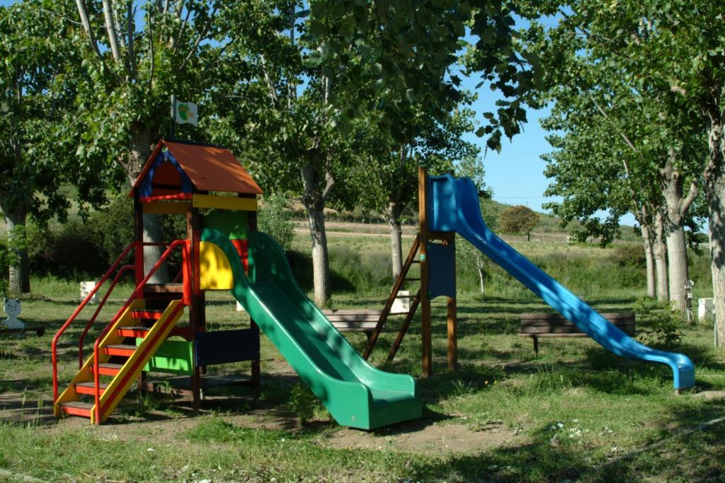 2 toboggans dans une aire de jeux avec des arbres en arrière-plan dans l'établissement CAMPING U SOMMALU, à Casaglione