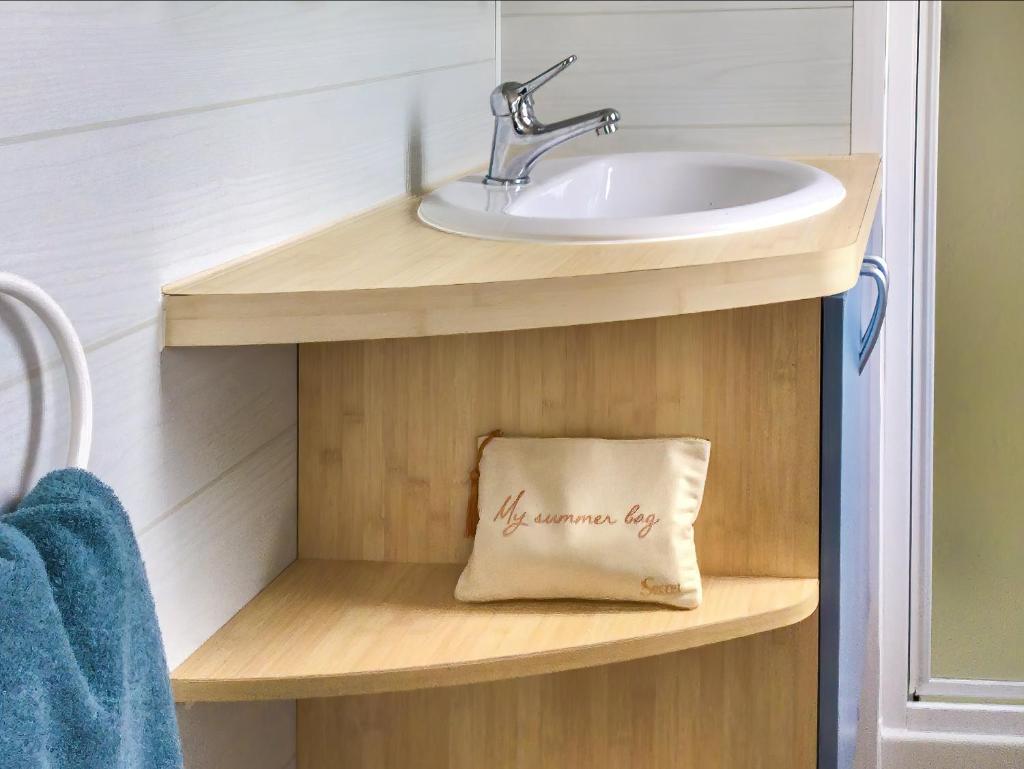 La salle de bains est pourvue d'un lavabo et d'une serviette sur une étagère. dans l'établissement Camping Paradis le Moulin des Oies, à Belz 37 autres photos