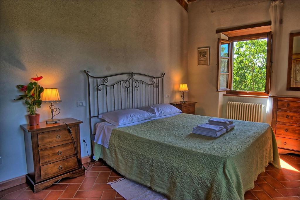 une chambre avec un grand lit et une fenêtre dans l'établissement Villa Il Prato, à San Pancrazio 85 autres photos