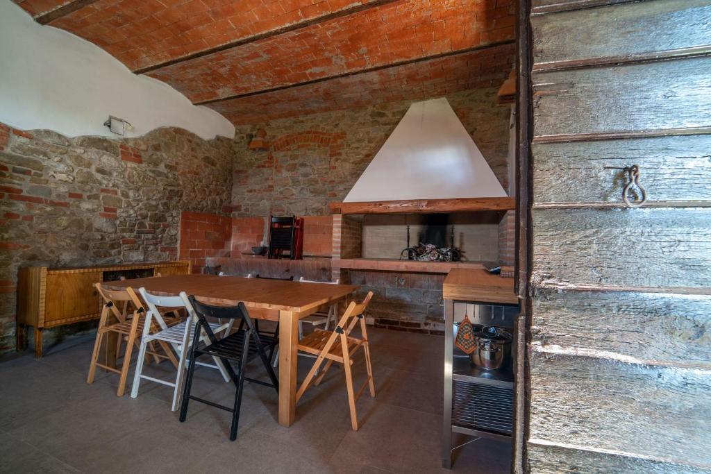 une cuisine avec une table et des chaises en bois dans l'établissement La Gropina Di Loro Ciuffenna, à Loro Ciuffenna