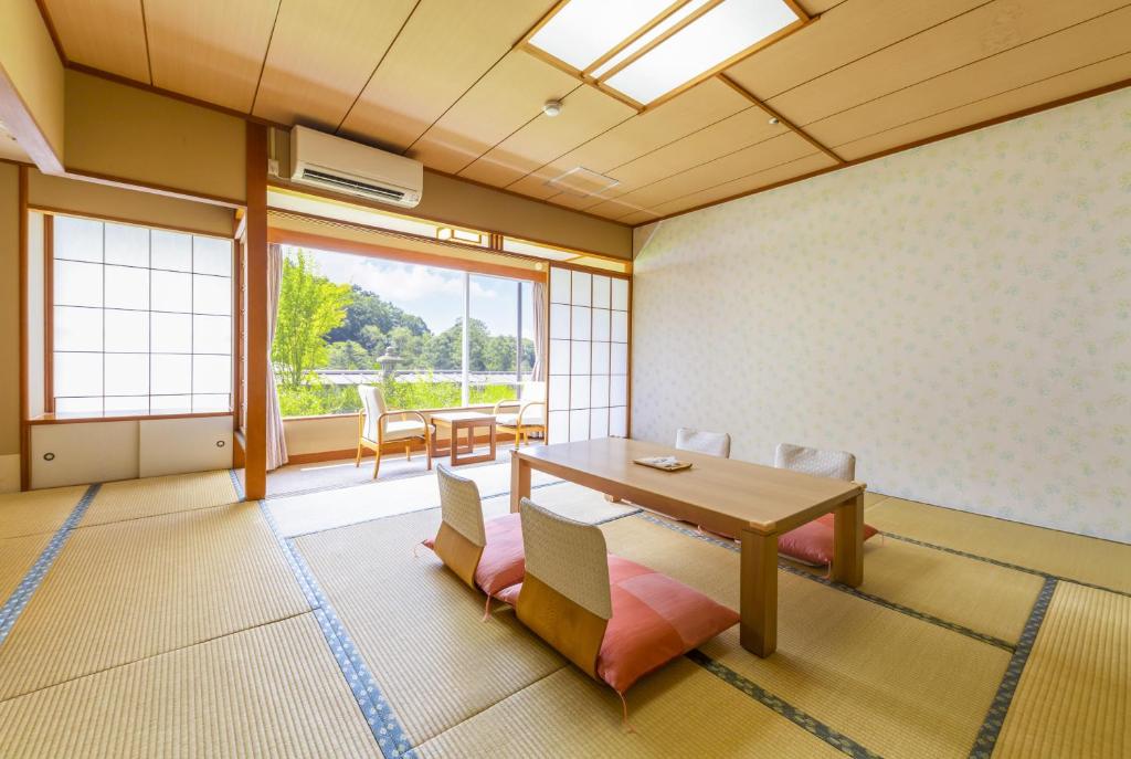 une salle à manger avec une table et des chaises et une grande fenêtre dans l'établissement Tateshina Grand Hotel Takinoyu, à Chino