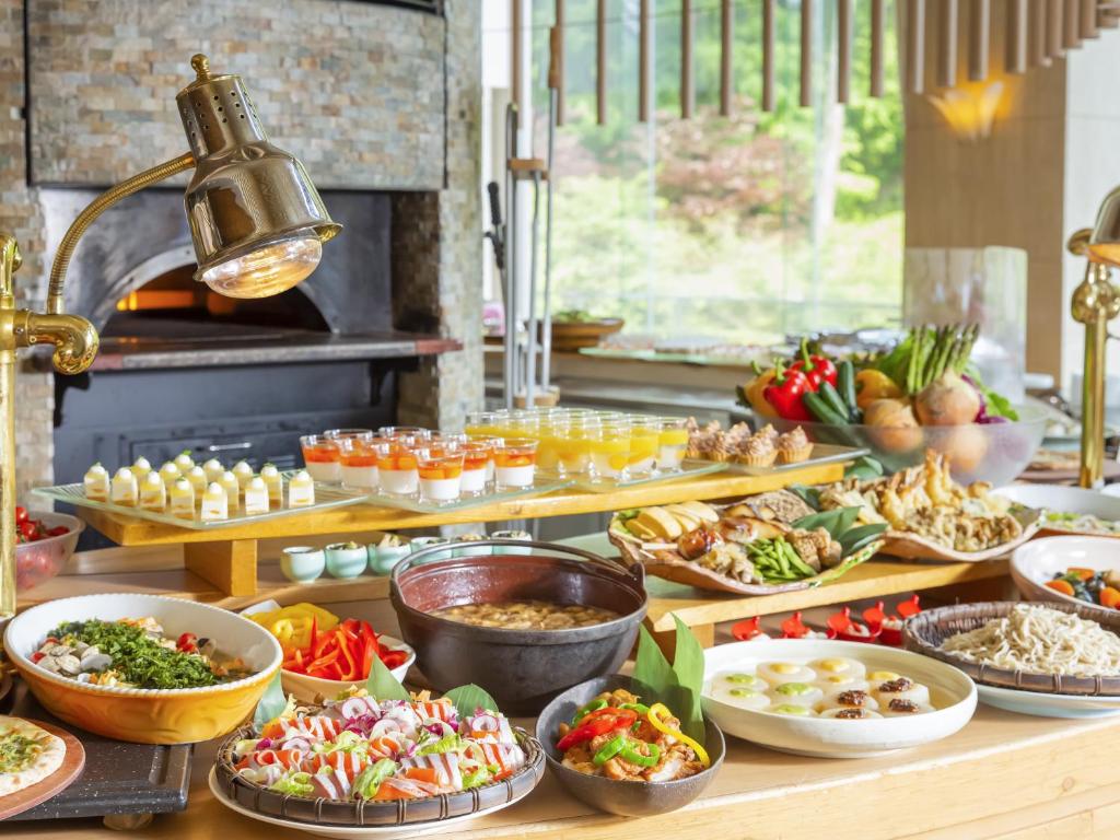 un buffet avec de nombreux types d'aliments différents sur une table dans l'établissement Tateshina Grand Hotel Takinoyu, à Chino