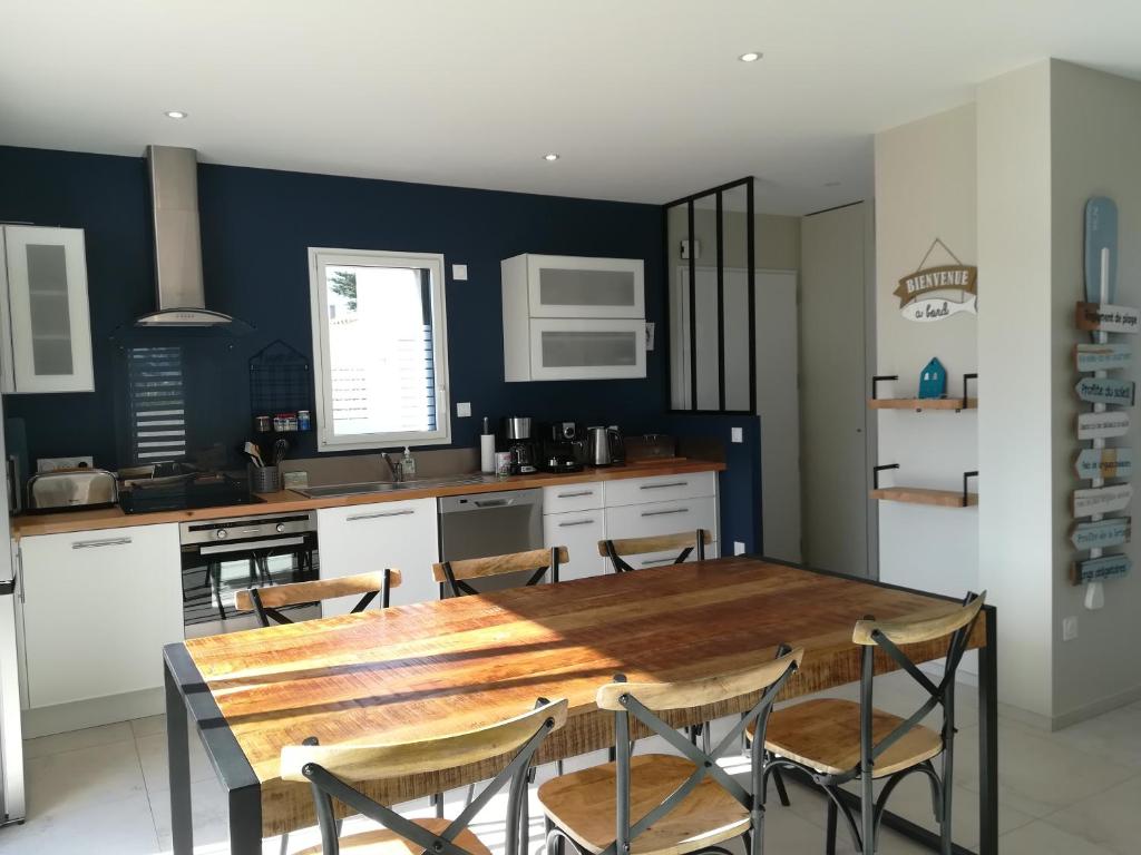 une cuisine avec une grande table et des chaises en bois dans l'établissement GITE LES BALISES-TRIBORD-SAINT GILLES CROIX DE VIE, à Saint-Gilles-Croix-de-Vie