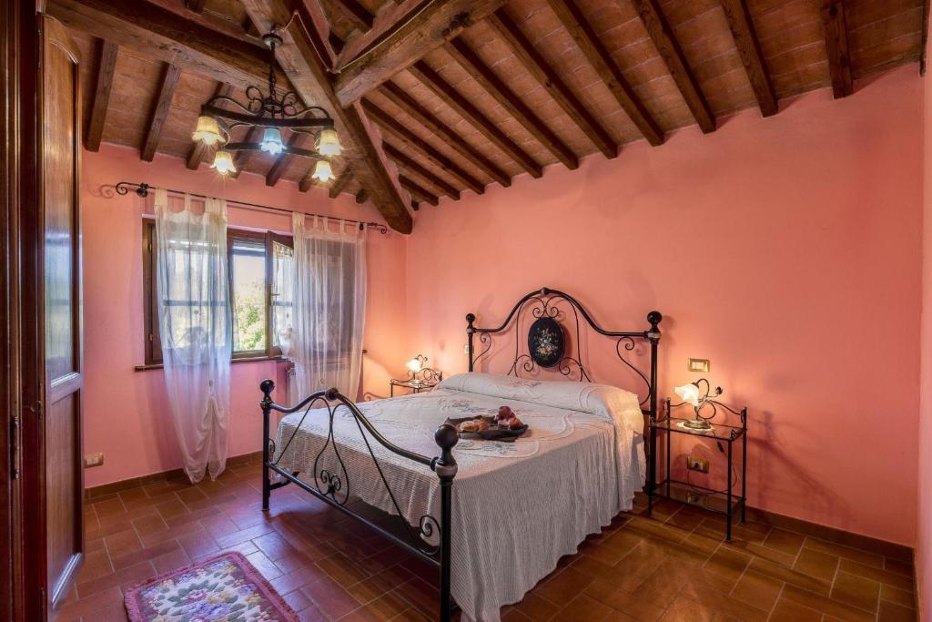 - une chambre avec un lit dans une pièce aux murs roses dans l'établissement Agriturismo La Fragola, à Cignano