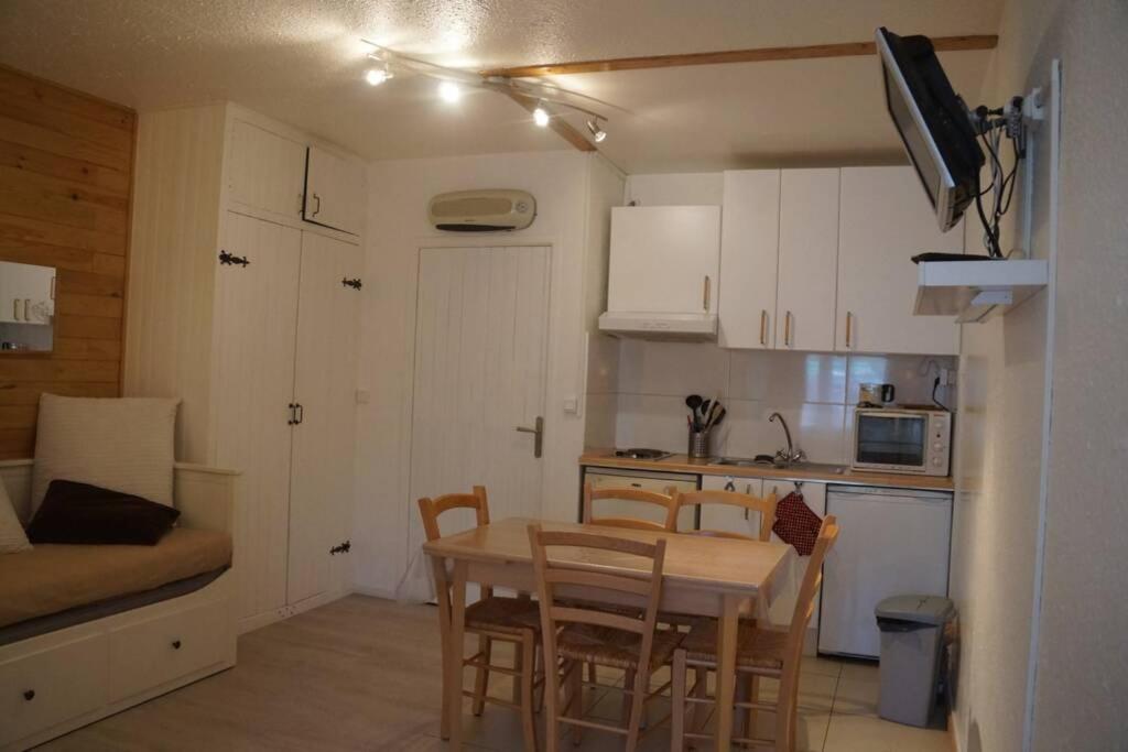 une cuisine et une salle à manger avec une table et des chaises dans l'établissement T2 Immeuble Chanteclerc 6 personnes 37m2 PRALOUP 1600, à Uvernet