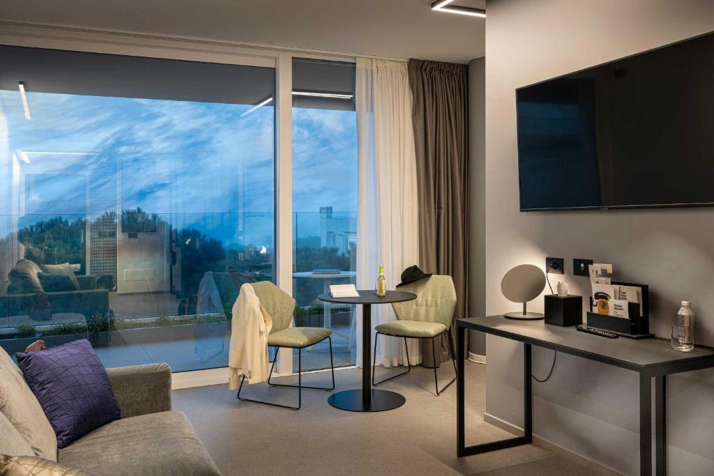un salon avec un canapé et une table avec des chaises dans l'établissement J44 Lifestyle Hotel, à Lido di Jesolo