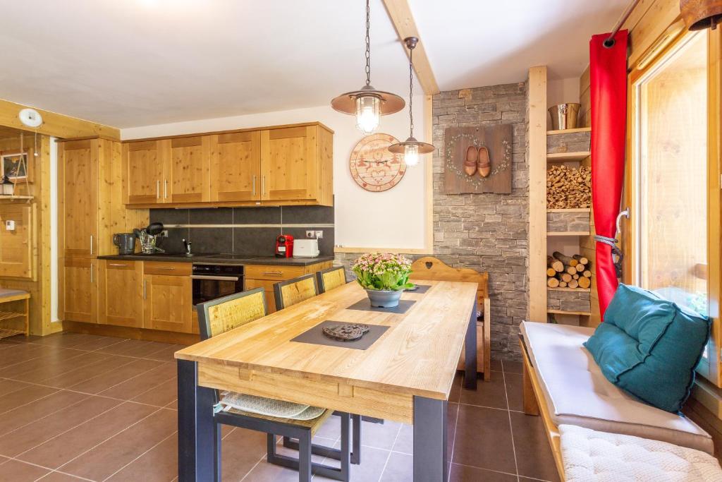 une cuisine et une salle à manger avec une table et des chaises en bois dans l'établissement Le Reclard - Les Balcons Etoilés, à Champagny-en-Vanoise