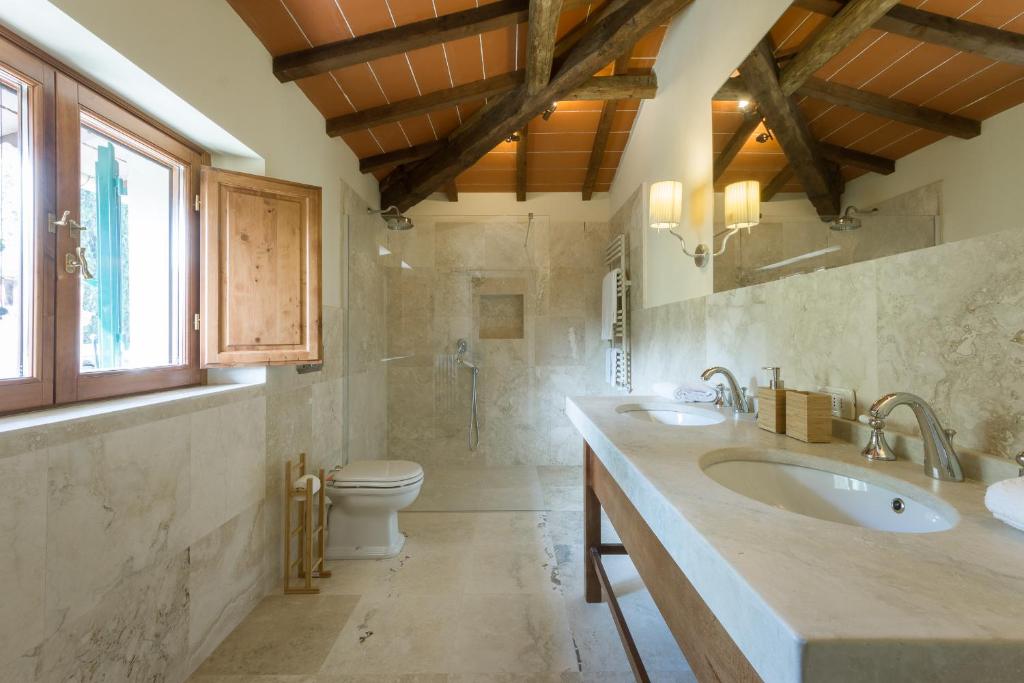 une salle de bain avec deux lavabos et un WC dans l'établissement VIlla Merlo Ner0, à Florence