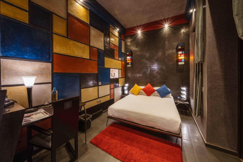 - une chambre avec un lit et un bureau avec un tapis rouge dans l'établissement Villa Makassar, à Marrakech 37 autres photos