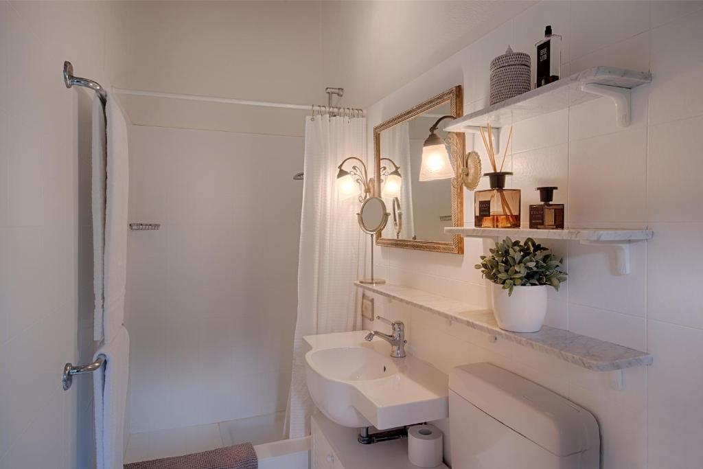 une salle de bain blanche avec un lavabo et une douche dans l'établissement Villa La Casina, à Castellina in Chianti 34 autres photos