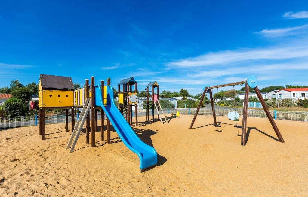 - une aire de jeux avec un toboggan bleu dans le sable dans l'établissement Mobil home climatisé ETANG DE BESSE, à La Parée Preneau