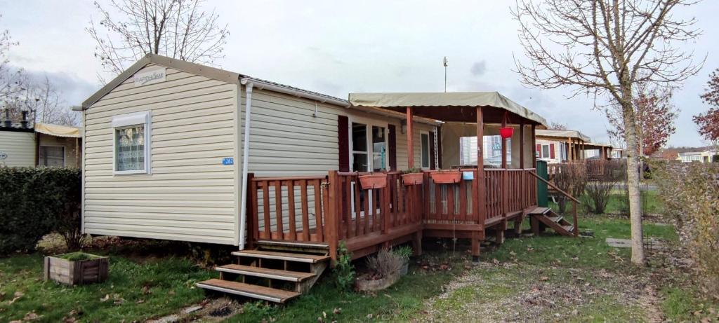 Cette petite maison blanche dispose d'une terrasse couverte et d'escaliers. dans l'établissement Assist' Mobil Home 262 - Mobil Home Excellence Bora Bora 3 chambres, à Onzain