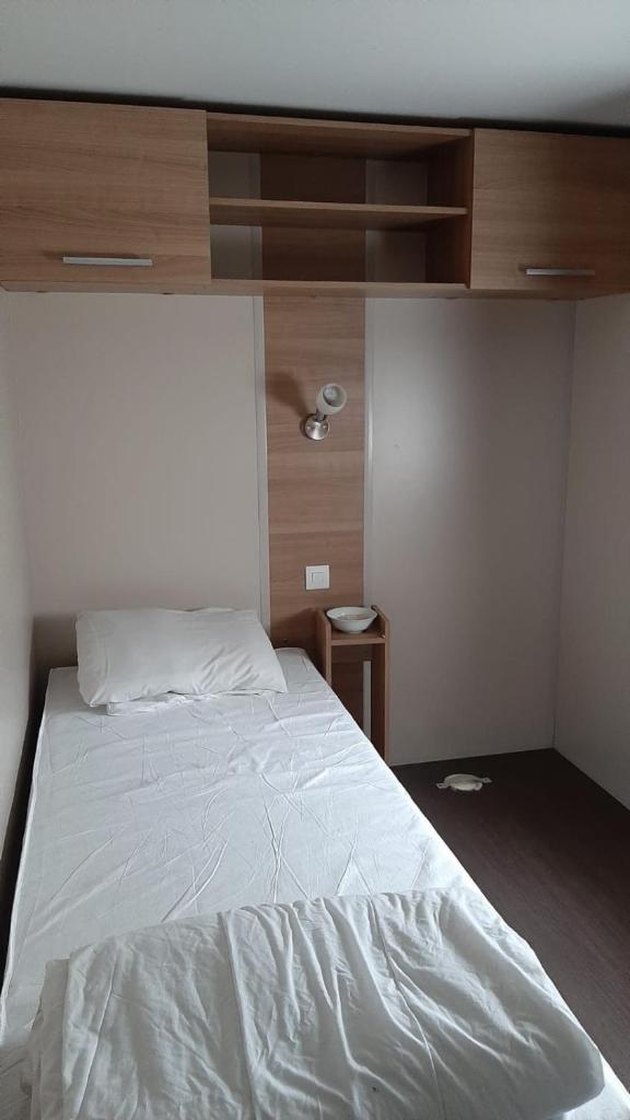 une chambre avec un lit blanc avec une tête de lit en bois dans l'établissement Assist' Mobil Home 262 - Mobil Home Excellence Bora Bora 3 chambres, à Onzain