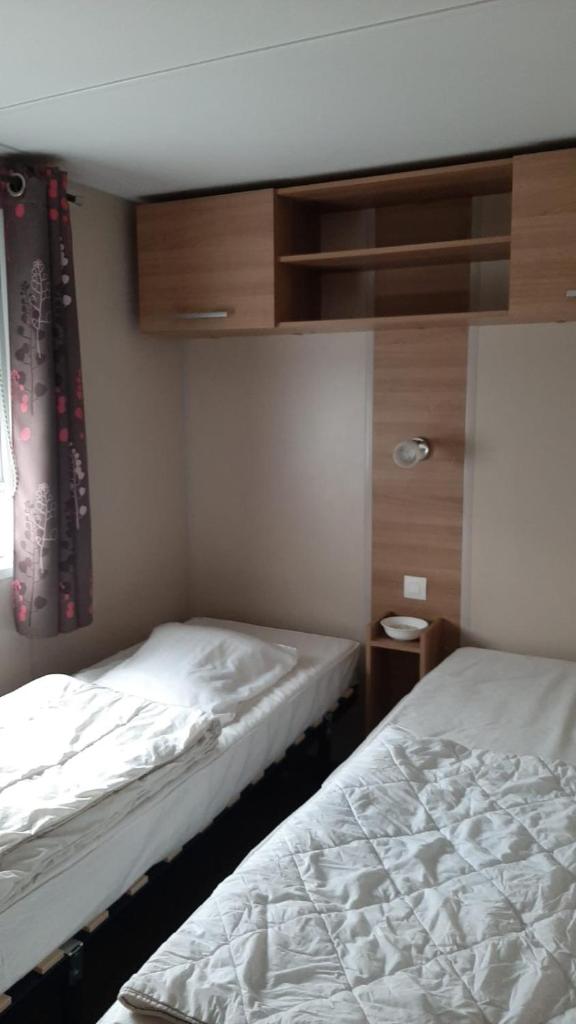 une chambre avec deux lits et une fenêtre dans l'établissement Assist' Mobil Home 262 - Mobil Home Excellence Bora Bora 3 chambres, à Onzain