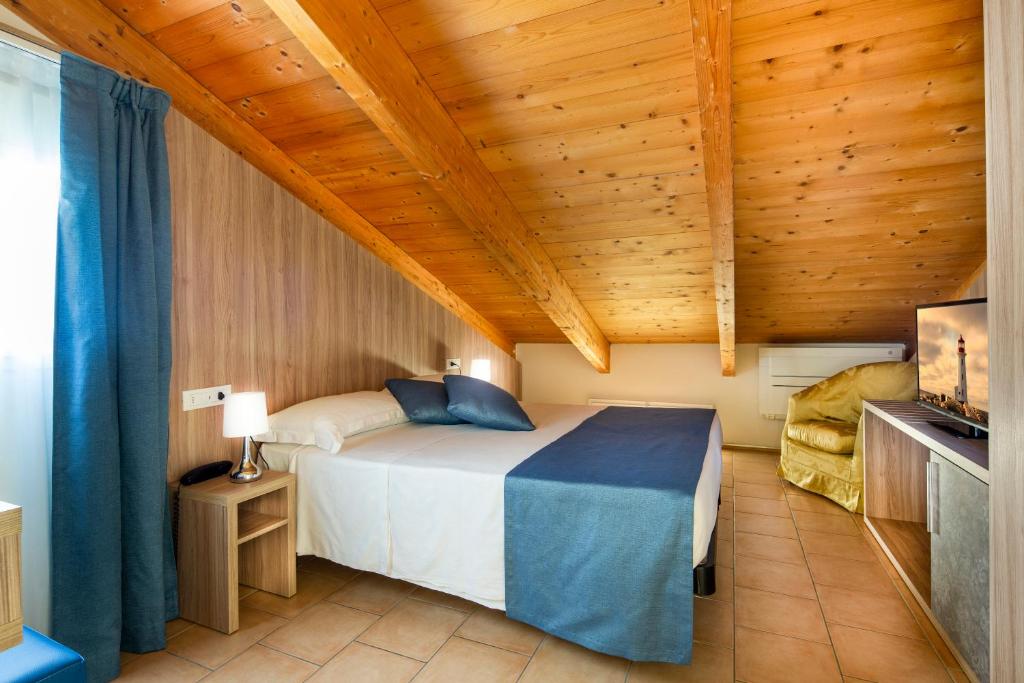 une chambre avec un lit et un plafond en bois dans l'établissement Mansarda Cannes, à Riccione