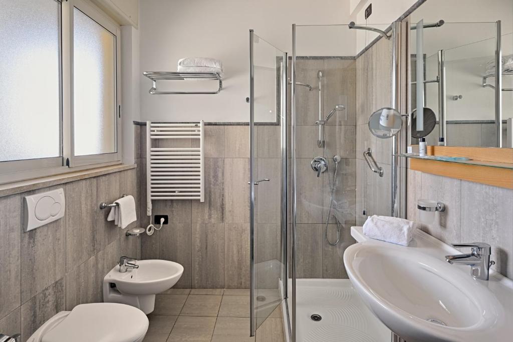 une salle de bain avec un lavabo, des toilettes et une douche dans l'établissement Aregai Marina Hotel & Residence, à Santo Stefano al Mare 65 autres photos