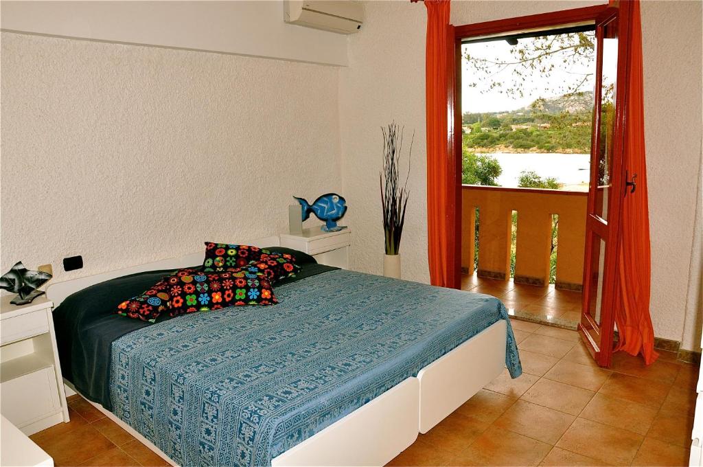 une chambre avec un lit avec une couverture bleue et une fenêtre dans l'établissement Club Esse Cala Bitta, à Baja Sardinia 67 autres photos