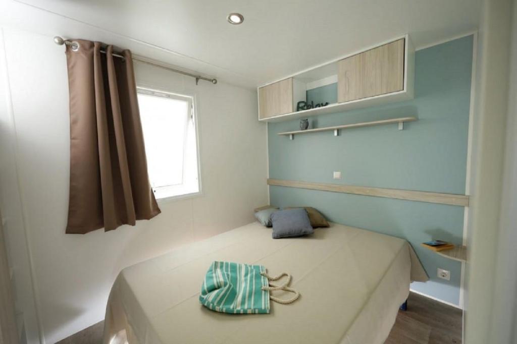 une petite chambre avec un lit et une fenêtre dans l'établissement CAMPING U SOMMALU, à Casaglione