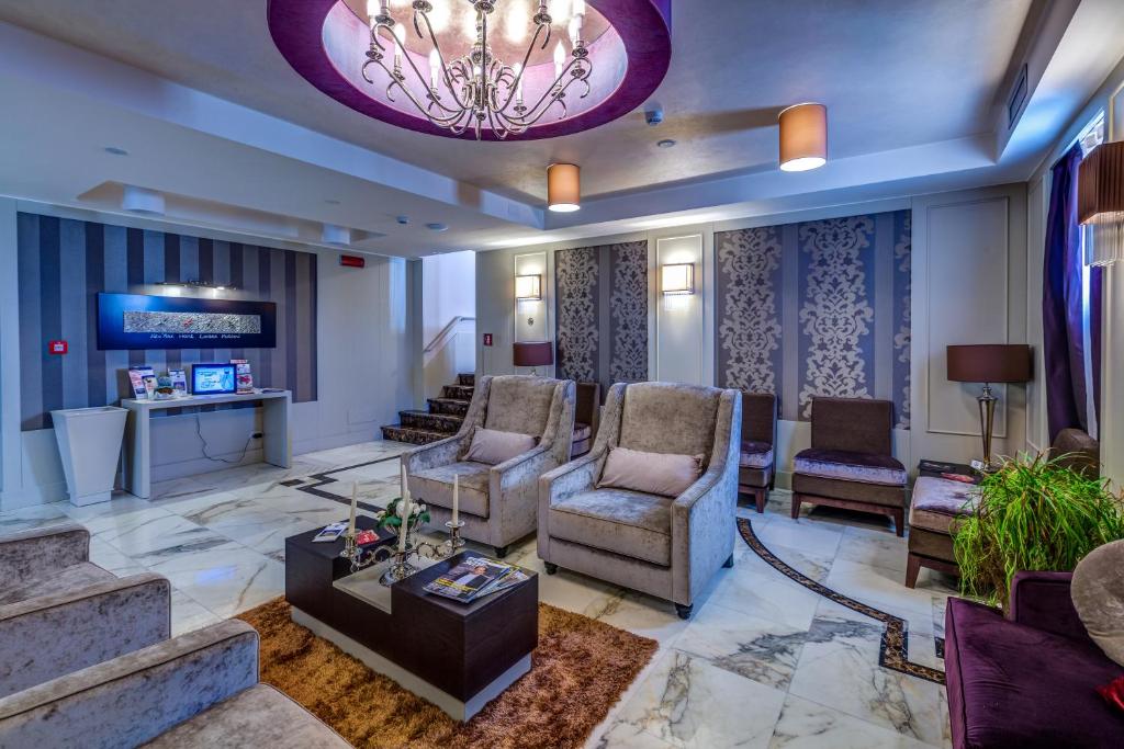 - un hall avec des chaises, une télévision et un lustre dans l'établissement Best Western Plus Hotel Perla Del Porto, à Catanzaro Lido