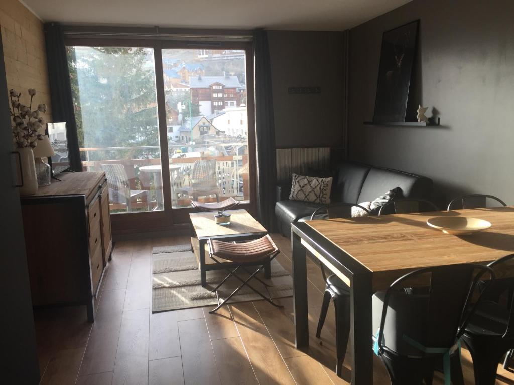 un salon avec une table et des chaises et une fenêtre dans l'établissement Le Paradis du Diable 6 pers 40m2 pied des pistes et du télésiège du diable, à Les Deux Alpes 12 autres photos