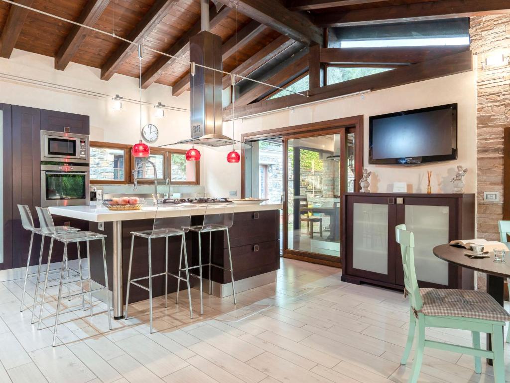 une cuisine avec une grande île dotée de chaises et d'une télévision dans l'établissement Villa Villa Monterosso - IMP420 by Interhome, à Imperia