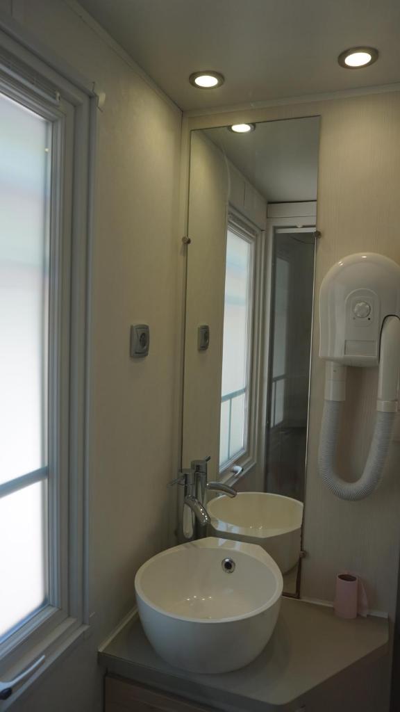 une salle de bain avec un lavabo et un grand miroir dans l'établissement Luxe chalet voor 5 personen op Camping Leï Suves - JoyCasa, à Roquebrune-sur Argens
